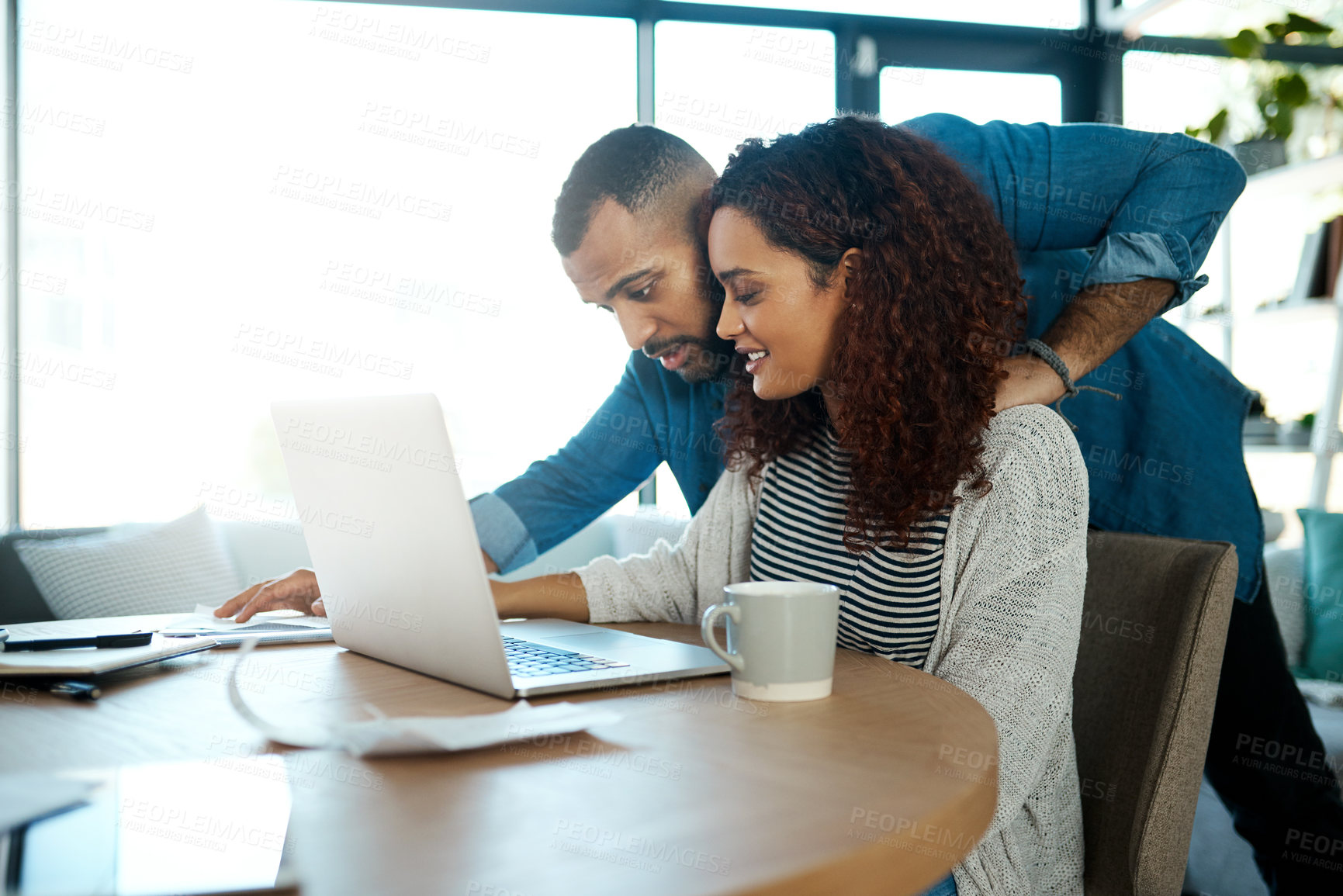 Buy stock photo Shot of a young couple planning their budget together on a laptop at home