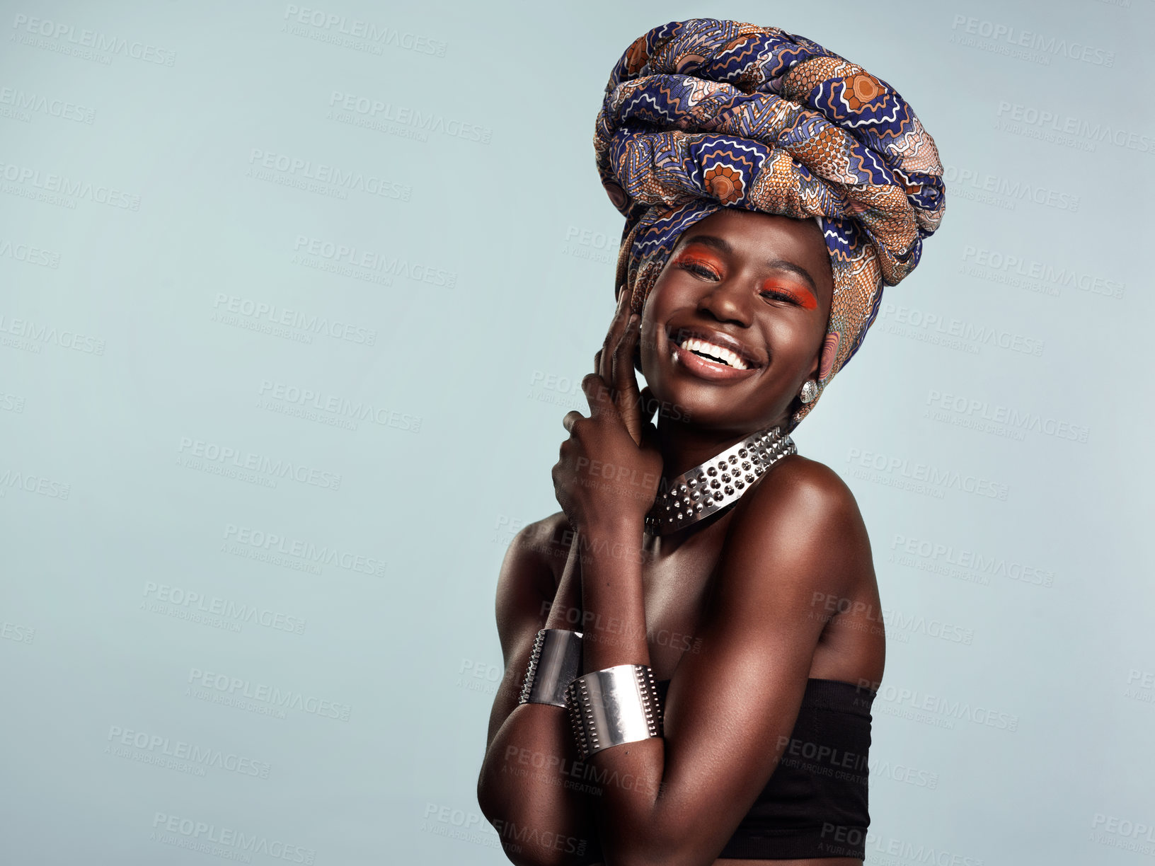 Buy stock photo Studio shot of a beautiful young woman wearing a traditional African head wrap against a grey background