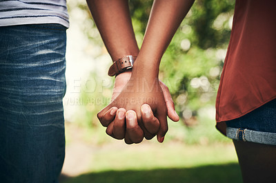 Buy stock photo Cropped shot of an unrecognizable couple standing hand in hand outside