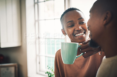Buy stock photo Shot of a beautiful young woman drinking coffee and having a chat with her husband at home