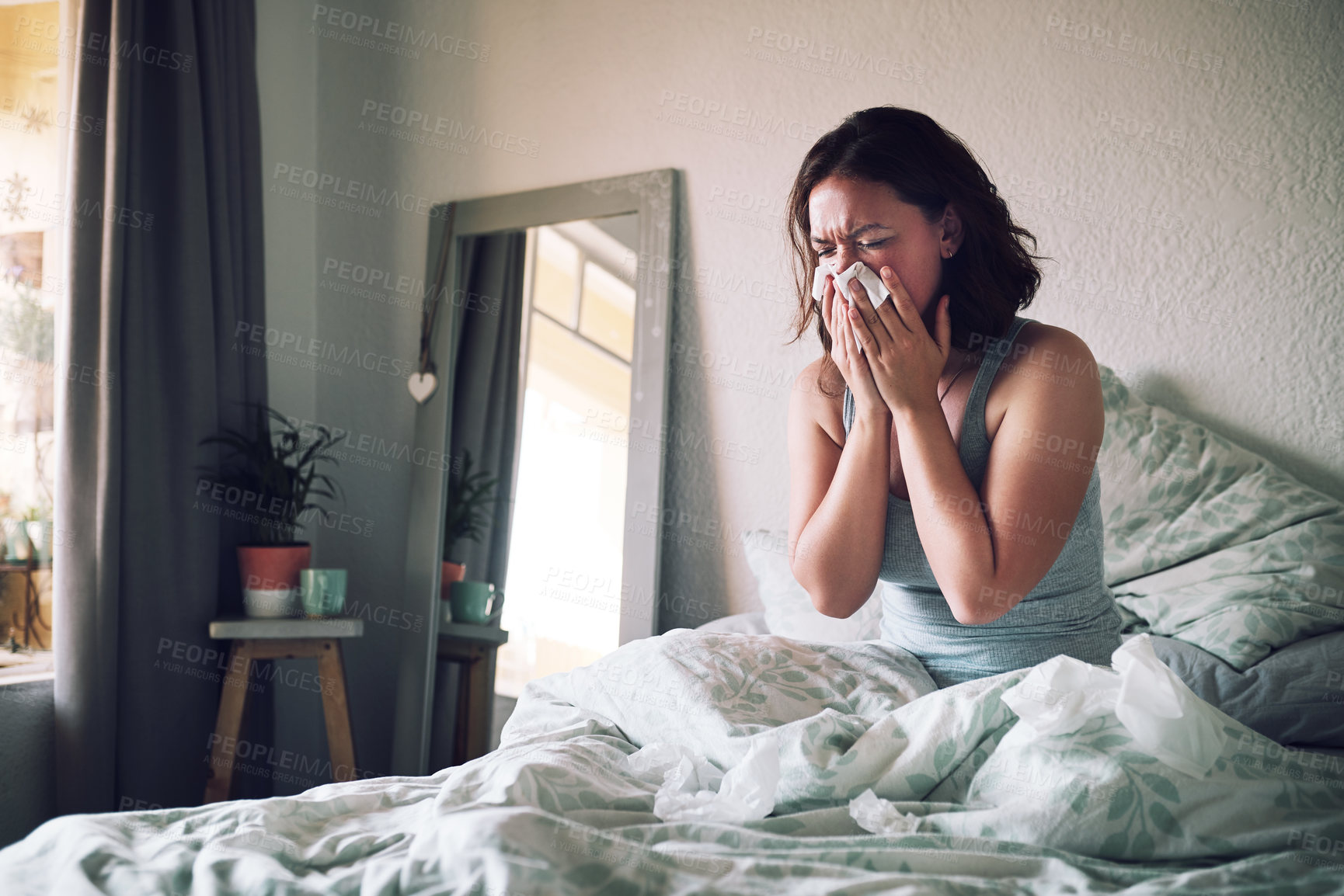 Buy stock photo Home, tissue and woman with the flu, allergy and sick in her apartment, couch and suffering. Female person, blowing nose or girl in her bedroom, health issue and illness with pain, tired or exhausted