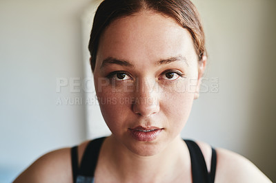 Buy stock photo Cropped shot of an attractive young woman standing alone and looking focused before working out in her home