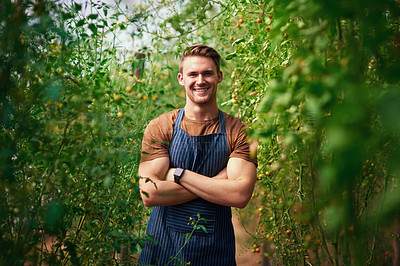 Buy stock photo Portrait of a handsome young farmer posing with his arms folded in the fields at his farm
