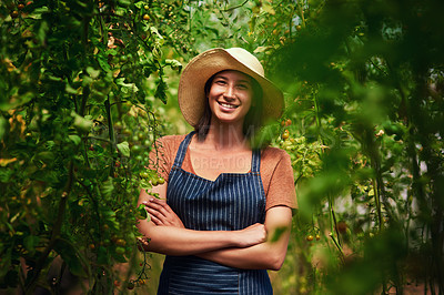 Buy stock photo Portrait of an attractive young female farmer posing with her arms folded outdoors in the fields at her farm