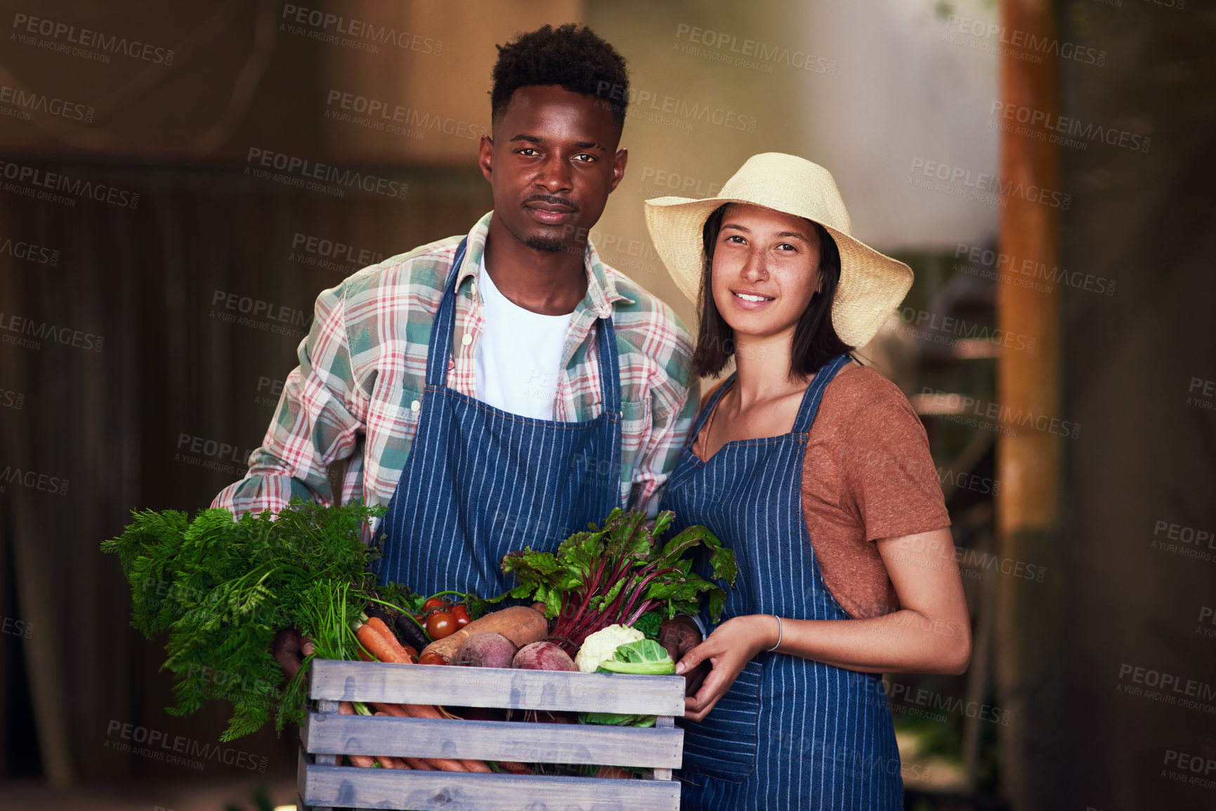 Buy stock photo Portrait of a happy young couple  carrying a crate full of freshly picked vegetables at their farm