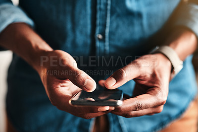 Buy stock photo Cropped shot of an unrecognizable businessman standing alone in his home office and texting on his cellphone