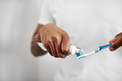 Buy stock photo Cropped shot of an unrecognizable man putting toothpaste on his toothbrush