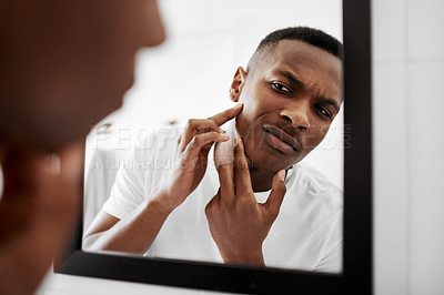 Buy stock photo Cropped shot of a young man squeezing pimples in the bathroom mirror