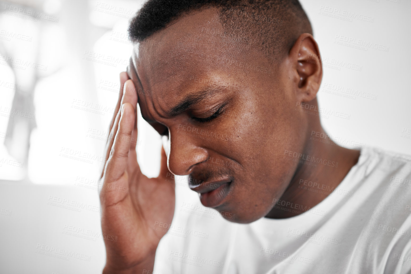 Buy stock photo Cropped shot of a young man suffering from a headache at home