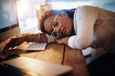 Buy stock photo Shot of a young businesswoman sleeping at her desk while working in an office at night