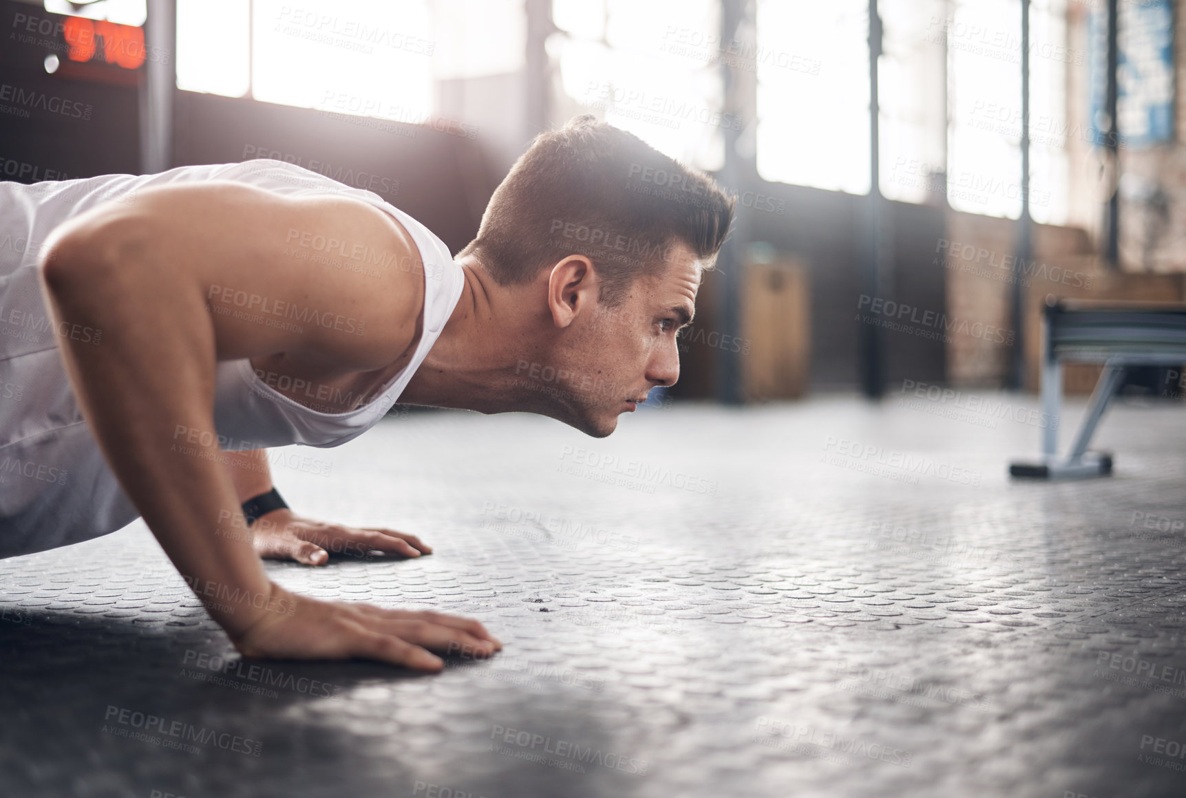 Buy stock photo Shot of a young man doing pushups in a gym