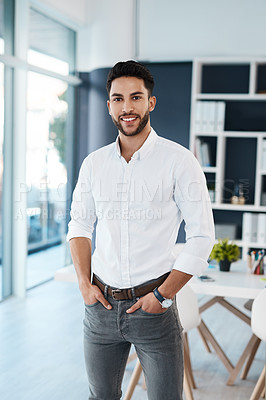 Buy stock photo Cropped portrait of a handsome young businessman standing alone in his office with his hands in his pockets