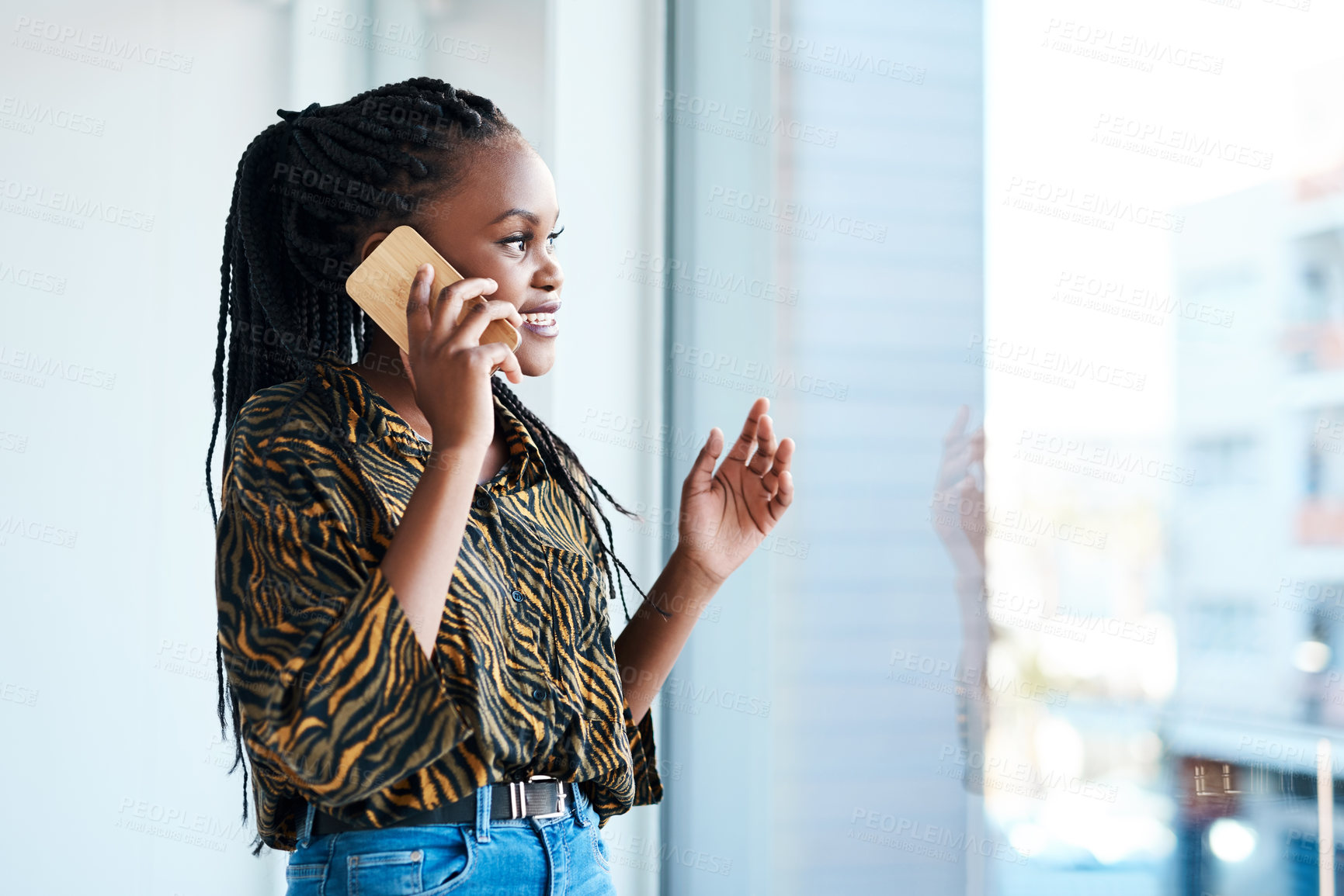Buy stock photo Cropped shot of an attractive young businesswoman standing in her office and talking on her cellphone