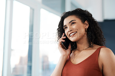 Buy stock photo Cropped shot of an attractive young businesswoman standing in her office and talking on her cellphone