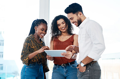 Buy stock photo Cropped shot of a diverse group of businesspeople standing in the office together and using a tablet