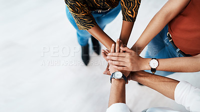 Buy stock photo High angle shot of an unrecognizable group of business colleagues standing together in the office and piling their hands together