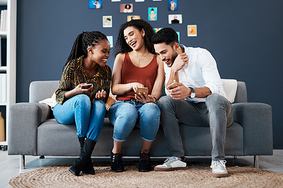 Buy stock photo Full length shot of a diverse group of business colleagues sitting on a sofa together and using a cellphone