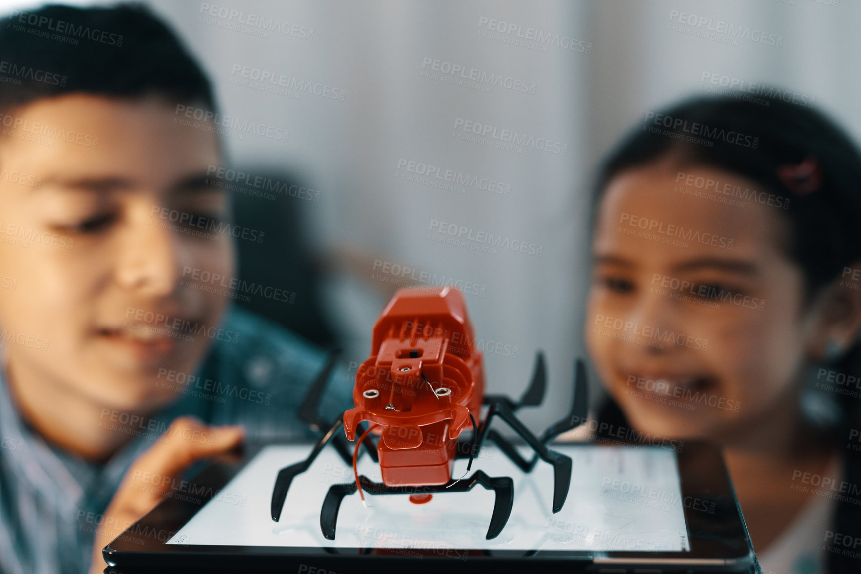 Buy stock photo Cropped shot of two young siblings looking at and admiring their robotic toy spider at home