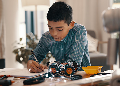 Buy stock photo Learning, writing in notebook and kid with robotics homework, homeschool and science for tech project. Taking notes, car robot and boy child with knowledge, education and studying in house alone.