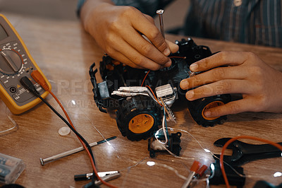 Buy stock photo Cropped shot of an unrecognizable young boy building a robotic toy car at home