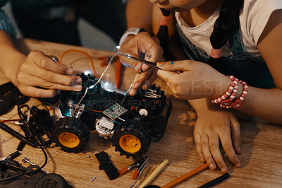 Buy stock photo Cropped shot of two unrecognizable young siblings building a robotic toy car together at home