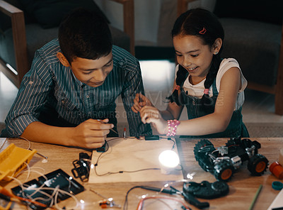 Buy stock photo Shot of two adorable young siblings making an electric circuit together at home