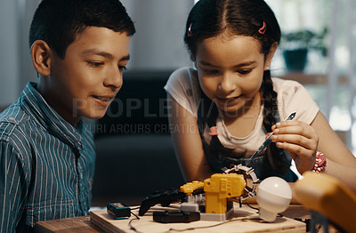 Buy stock photo Shot of two adorable young siblings building a robotic toy together at home