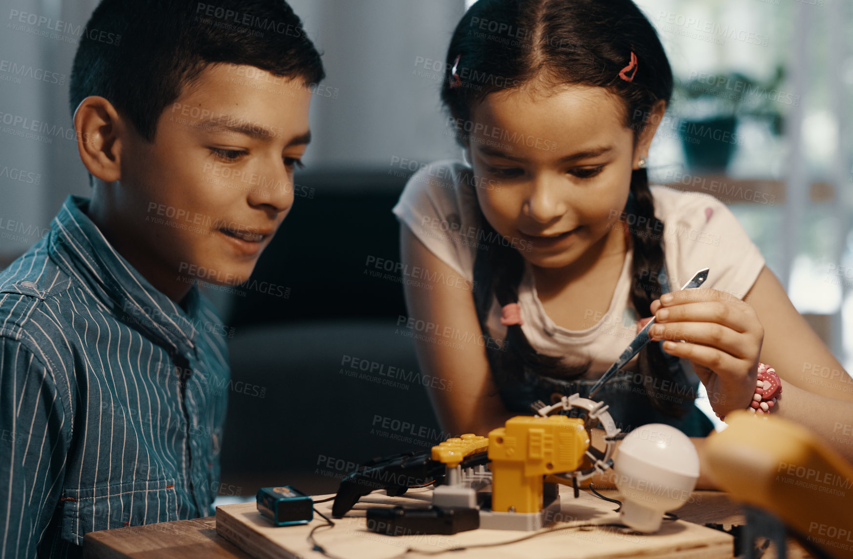 Buy stock photo Shot of two adorable young siblings building a robotic toy together at home