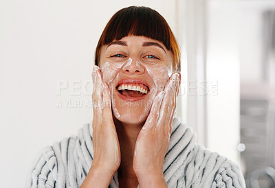 Buy stock photo Cropped portrait of an attractive young woman smiling while  applying beauty treatment on her face at home
