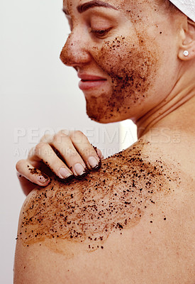 Buy stock photo Cropped shot of an attractive young woman smiling while applying a coffee mask on her body at home