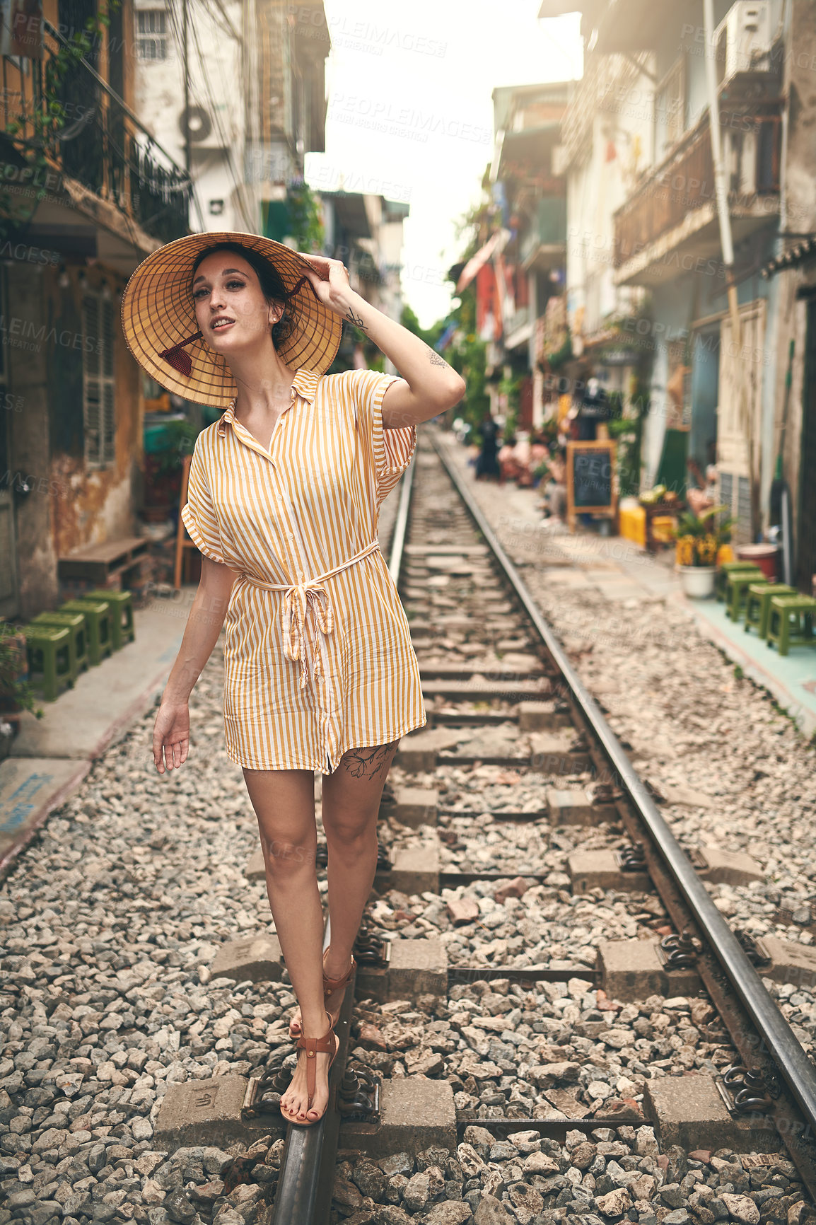 Buy stock photo Travel, walking and woman on train track in Vietnam for holiday, vacation and tourist destination. Fashion, curious and person on railway for adventure, journey and explore landmark in urban city