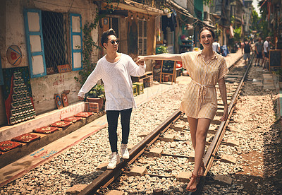 Buy stock photo Couple, happy and walking by railway for travel, relationship and holiday adventure with portrait. People, trip and love in Vietnam for vacation, romance and holding hands on date with train track