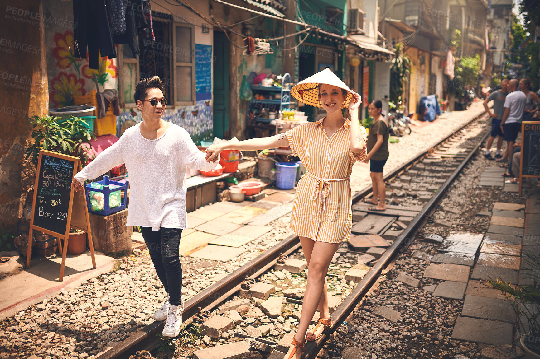 Buy stock photo Couple, portrait and walking by railway for travel, relationship and holiday adventure with love. People, trip and happy in Vietnam for vacation, romance and holding hands on date with train track