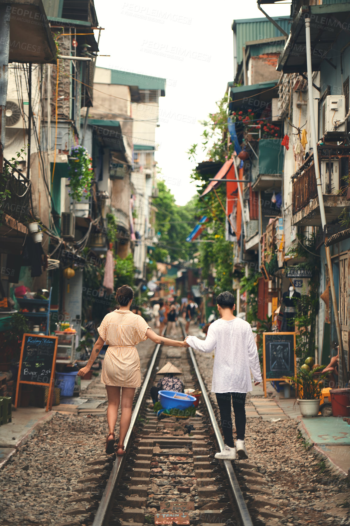 Buy stock photo Travel, railway and back of couple in Vietnam for holiday, vacation and tourist destination. Holding hands, love and man and woman on train tracks for adventure, journey and bonding in urban city