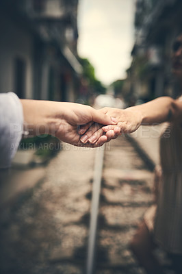 Buy stock photo Holding hands, couple and outdoor on train track in city, travel and connection for love on vacation. People, railway and bonding in metro town with care, loyalty or trust for relationship in Vietnam