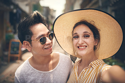 Buy stock photo Shot of a young couple taking a selfie while exploring the city of Vietnam