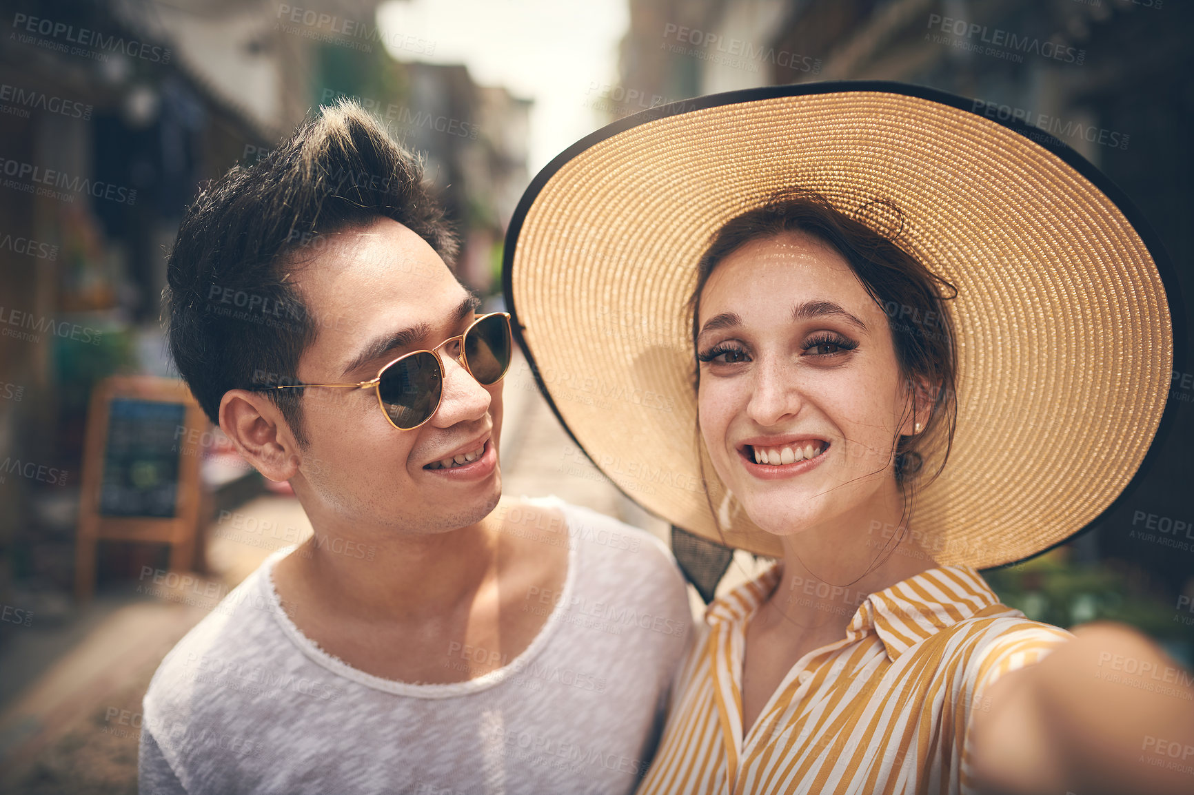 Buy stock photo Shot of a young couple taking a selfie while exploring the city of Vietnam