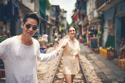 Buy stock photo Shot of a young couple walking through the streets of Vietnam