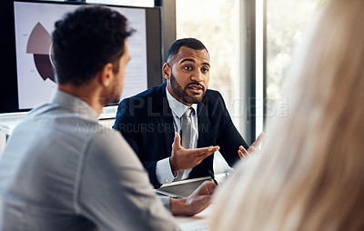 Buy stock photo Shot of a group of young businesspeople having a meeting in the boardroom of a modern office