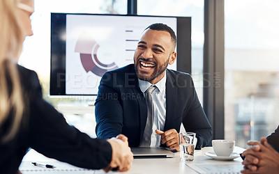 Buy stock photo Shot of a young businessman and businesswoman shaking hands during a meeting in a modern office