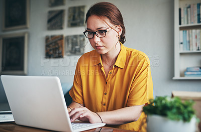 Buy stock photo Cropped shot of an attractive young businesswoman sitting alone in her home office and using her computer