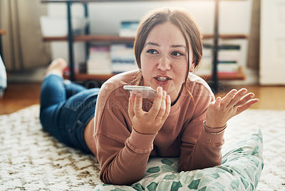 Buy stock photo Full length shot of an attractive young woman lying on her living room floor and talking on her cellphone