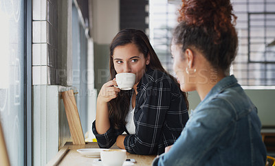 Buy stock photo Shot of two young women chatting in a cafe