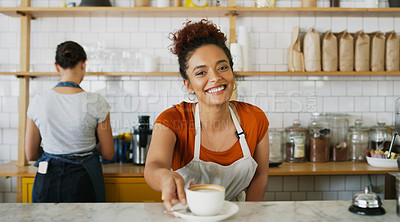Buy stock photo Portrait of a young waitress serving a cup of coffee in a cafe