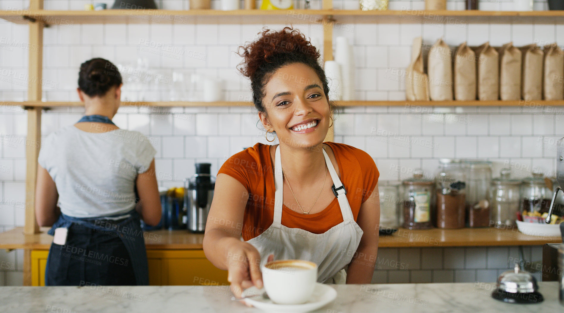 Buy stock photo Portrait of a young waitress serving a cup of coffee in a cafe