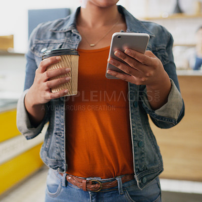 Buy stock photo Closeup shot of an unrecognisable woman using a cellphone while holding a cup of coffee in a cafe