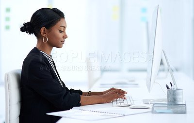 Buy stock photo Shot of an attractive young businesswoman working on a computer inside her office