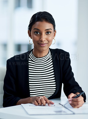 Buy stock photo Portrait of an attractive young businesswoman working and writing down notes in her journal at work