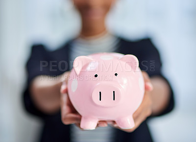 Buy stock photo Cropped shot of an unrecognizable businesswoman holding a piggy bank inside her office