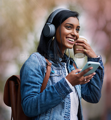 Buy stock photo Headphones, mobile or Indian woman in city on social media for streaming a song, music or radio. Travel, student or happy girl listening to audio on online subscription or phone with coffee on break